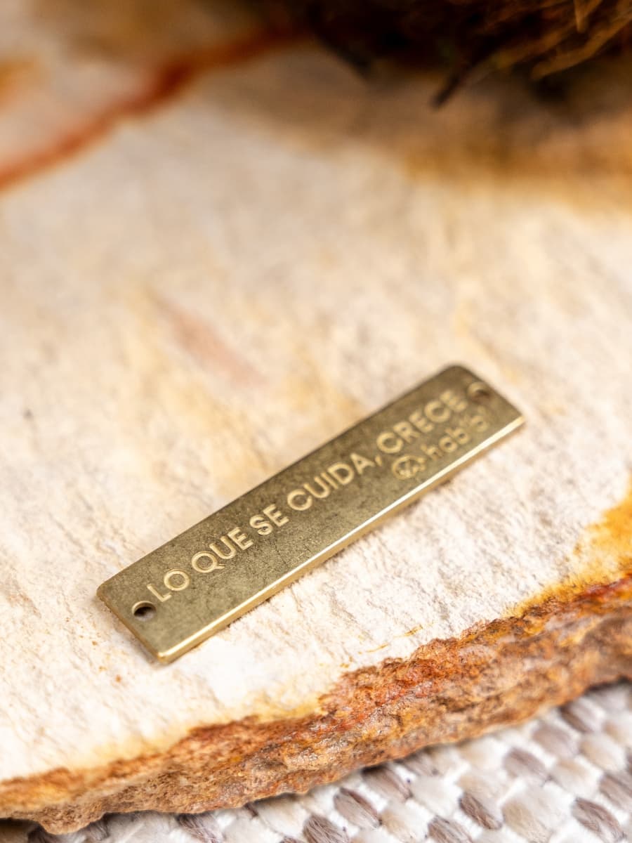 Placa en metal grabada «Lo que se cuida, crece» sobre la piedra natural — Habibi